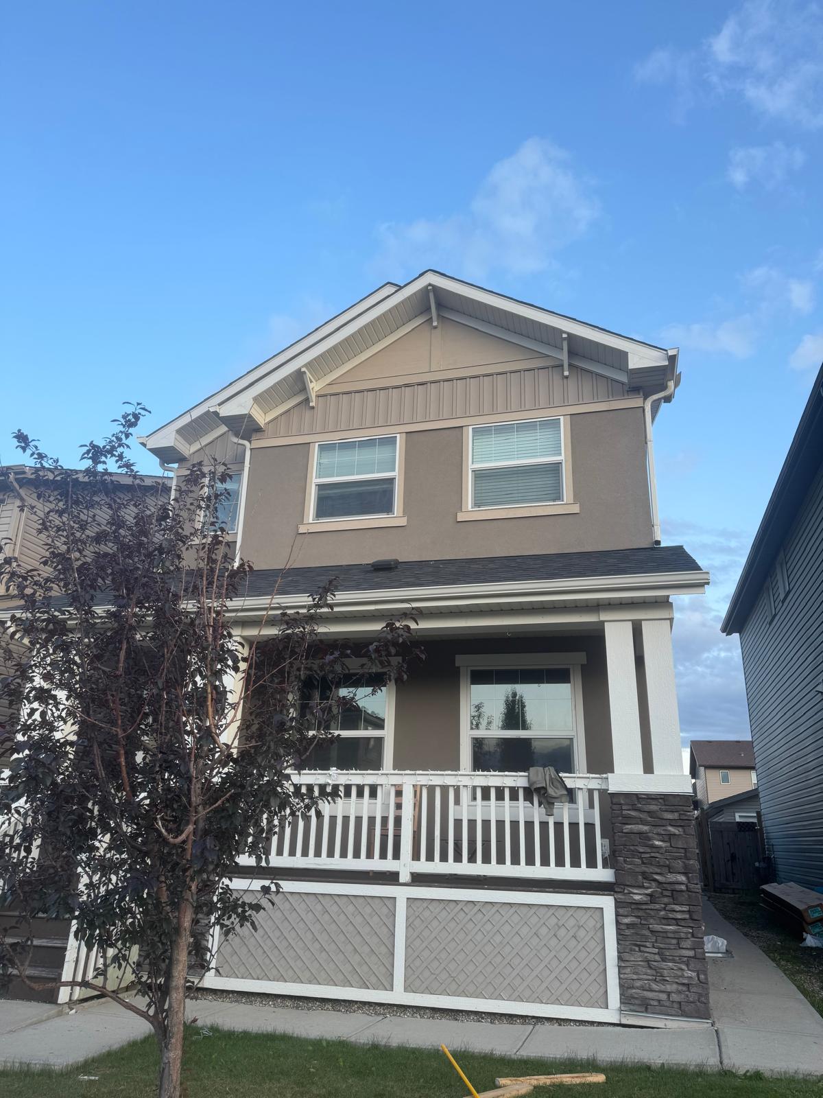 Elegant Calgary home with cream-colored vinyl siding and stone accents